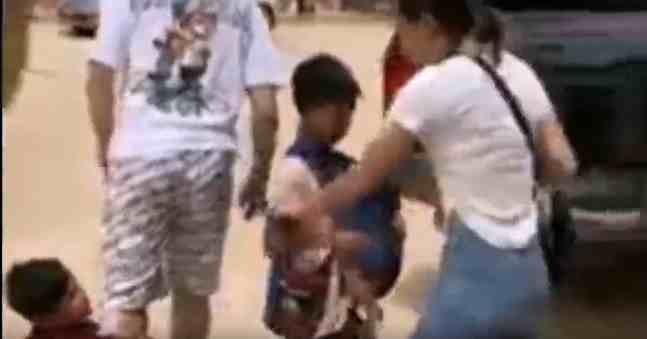 缅北老街市的小乞丐抱着一名男子大腿，另一名女性试图解围险遭“袭胸”